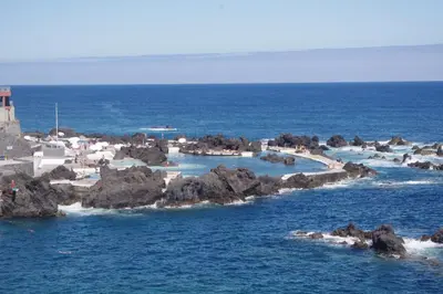 a resort in the ocean with rocks in the water at Palm Comfort in São Vicente