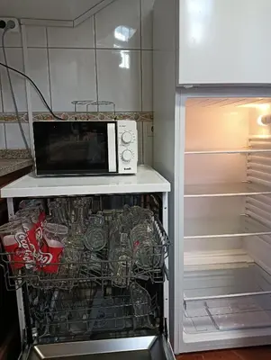 a microwave oven sitting on top of a refrigerator at Palm Comfort in São Vicente
