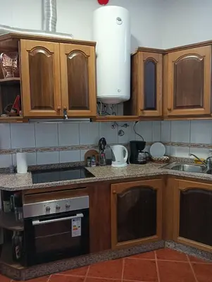 a kitchen with wooden cabinets and a sink at Palm Comfort in São Vicente