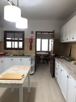 a kitchen with white cabinets and a table in it at Casa Dona Teresa in Santa Cruz