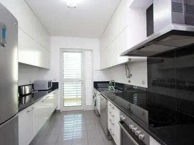a kitchen with white cabinets and black counter tops at Apartamento Lugar do Mar ,wonderful sea view in Funchal