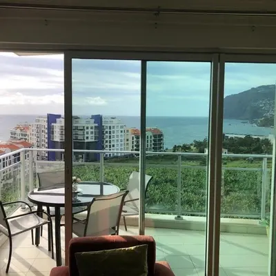 a balcony with a table and chairs and a view of the ocean at Apartamento Lugar do Mar ,wonderful sea view in Funchal