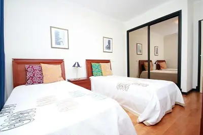 a bedroom with two beds and a mirror at Apartamento Lugar do Mar ,wonderful sea view in Funchal