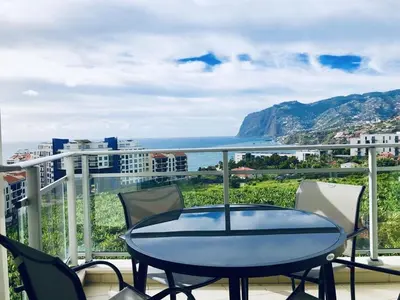 a living room with a table and chairs and a couch at Apartamento Lugar do Mar ,wonderful sea view in Funchal