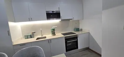 a white kitchen with white cabinets and a sink at City Nest in Funchal