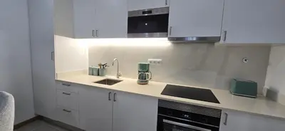 a kitchen with white cabinets and a sink at City Nest in Funchal