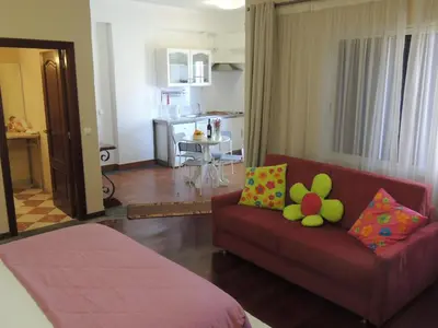 a living room with a red couch and a kitchen at Studio Flat with Pool in Funchal