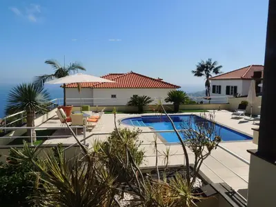 a house with a swimming pool in front of a house at Studio Flat with Pool in Funchal