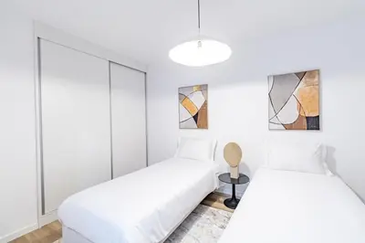 two beds in a room with white walls at Sunset Cove in Funchal