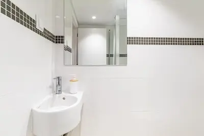 a white bathroom with a sink and a mirror at Sunset Cove in Funchal