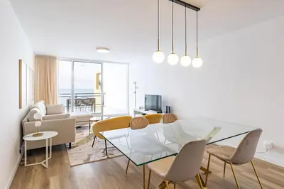 a living room with a glass table and chairs at Sunset Cove in Funchal