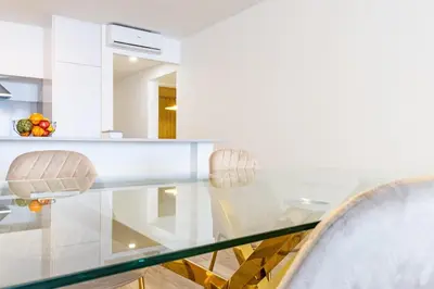 a dining room with a glass table and two chairs at Sunset Cove in Funchal