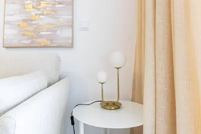 a table with a lamp on it next to a bed at Sunset Cove in Funchal