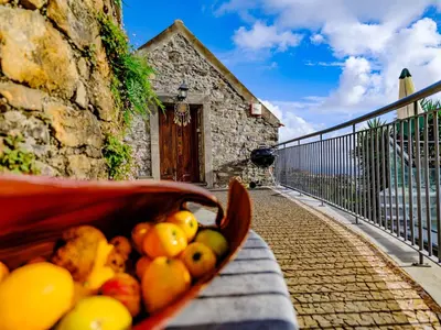 a basket of fruit is sitting on a wall at Cabana da Quinta Girassol by YMR in Ponta do Sol