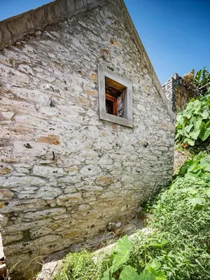 a window in the side of a stone building at Cabana da Quinta Girassol by YMR in Ponta do Sol