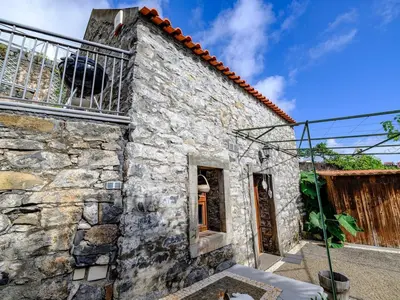 a stone building with a balcony on top of it at Cabana da Quinta Girassol by YMR in Ponta do Sol