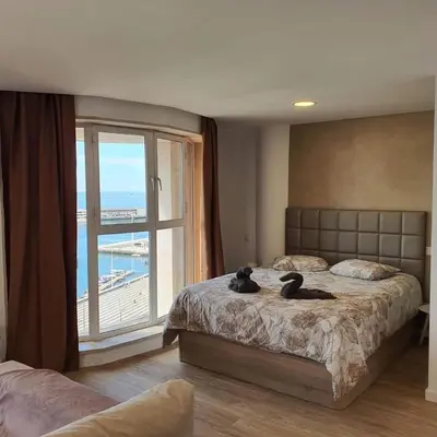 a bedroom with two beds and a large window at Center Marina view Gold Studio in Funchal