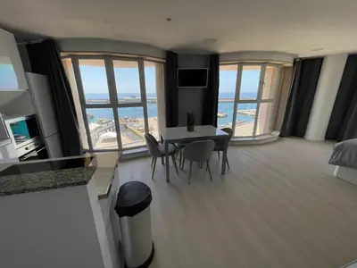 a living room with a table and chairs and windows at Center Marina view Silver Studio in Funchal