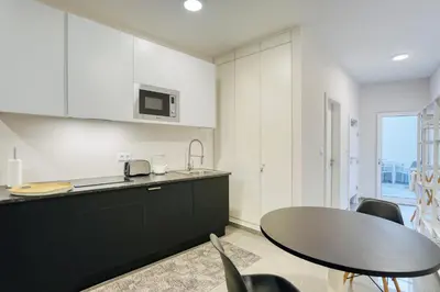 a kitchen with a table and some chairs at Mouraria Studios in Funchal
