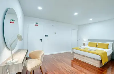 a bedroom with a bed and a desk and a chair at Mouraria Studios in Funchal