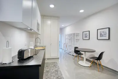 a kitchen with a counter and a table and chairs at Mouraria Studios in Funchal