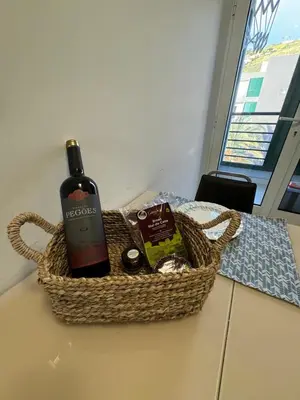 a basket with a bottle of wine on a table at Fórum Plaza III in Funchal