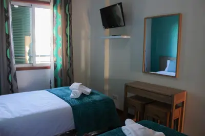 a hotel room with a bed and a mirror at Fórum Plaza III in Funchal