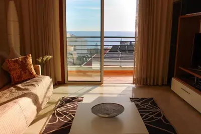 a living room with a couch and a large window at Fórum Plaza III in Funchal