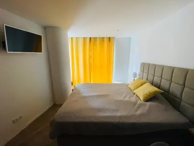 a bedroom with a bed with a yellow pillow on it at Center Marina view Yellow Studio in Funchal