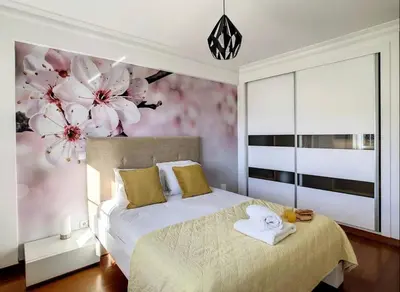 a bedroom with a bed with flowers on the wall at VeBella Abegoaria in Caniço