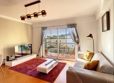 a living room with a couch and a large window at VeBella Abegoaria in Caniço