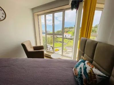 a bedroom with a bed and a large window at Center Marina view Purple Studio in Funchal