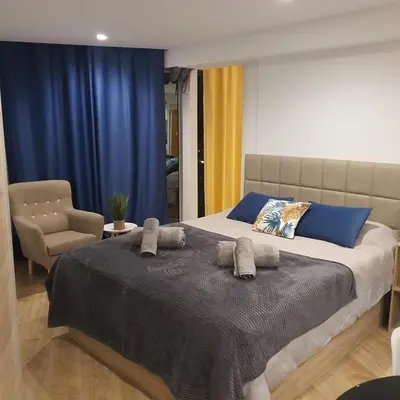 a bedroom with a large bed and a chair at Center Marina view Purple Studio in Funchal
