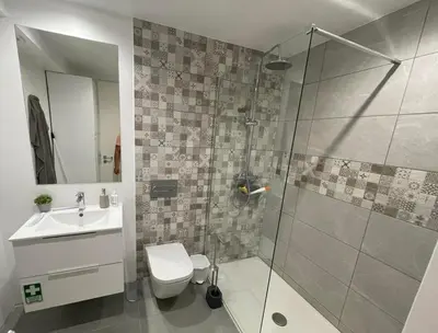 a bathroom with a shower and a toilet and a sink at Center Marina view Purple Studio in Funchal
