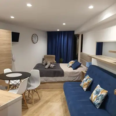 a bedroom with a bed and a blue couch at Center Marina view Purple Studio in Funchal