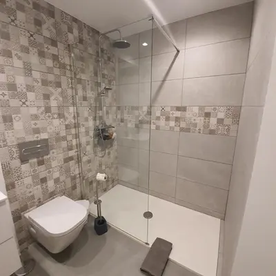 a bathroom with a toilet and a glass shower at Center Marina view Purple Studio in Funchal