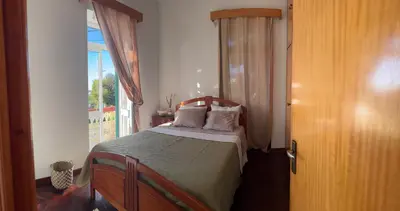 a small bedroom with a yellow bed and a window at Descanso imparcial in Prazeres