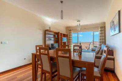 a dining room and living room with a table and chairs at Garajau View Apartment by Holiday Rental Madeira in Caniço