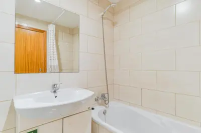 a white bathroom with a sink and a bath tub at Estetania Apartment by AH in Santa Cruz