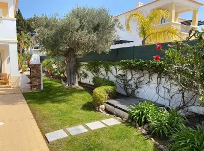 a garden with a tree and a house at Praia da Luz Mandeliu Exclusive 5 Star Private Villa Heated Pool in Luz