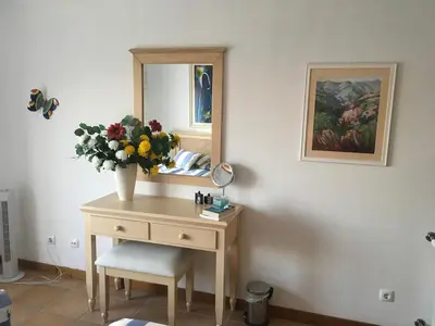 a dressing table with a vase of flowers and a mirror at Praia da Luz Mandeliu Exclusive 5 Star Private Villa Heated Pool in Luz