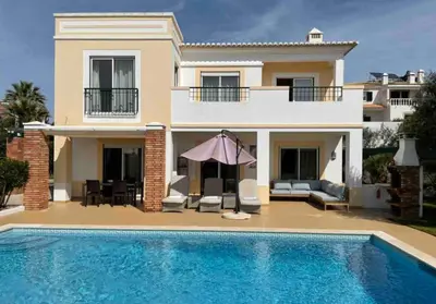 a villa with a swimming pool in front of a house at Praia da Luz Mandeliu Exclusive 5 Star Private Villa Heated Pool in Luz