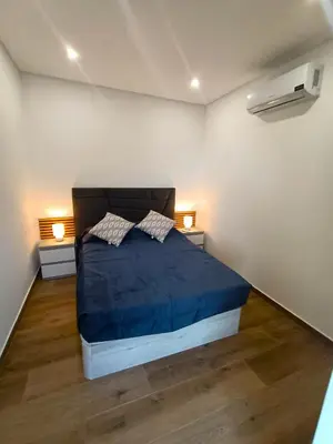 a bedroom with a bed with blue sheets and two lamps at 26 Steps in Calheta
