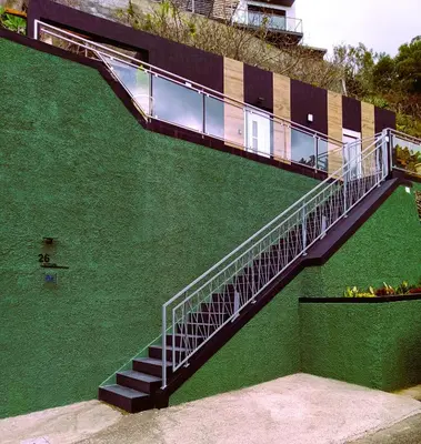 a staircase on the side of a green building at 26 Steps in Calheta
