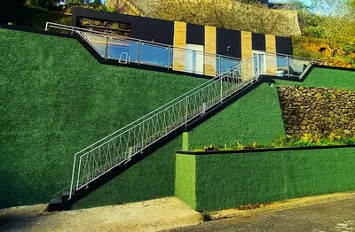 a building with a staircase on the side of a green wall at 26 Steps in Calheta
