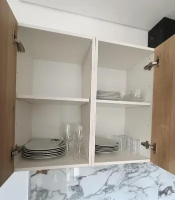 a white cabinet with plates and glasses in it at 26 Steps in Calheta