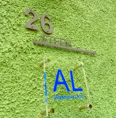 a sign on the side of a green wall with aza sign at 26 Steps in Calheta