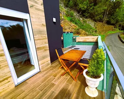 a balcony with a wooden table and a potted plant at 26 Steps in Calheta