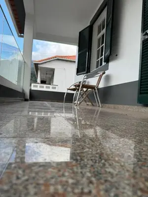a chair sitting on the porch of a house at Holiday home with game room and entertainment in São Vicente