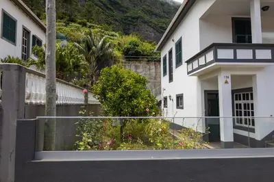 a white house with a fence in front of it at Holiday home with game room and entertainment in São Vicente